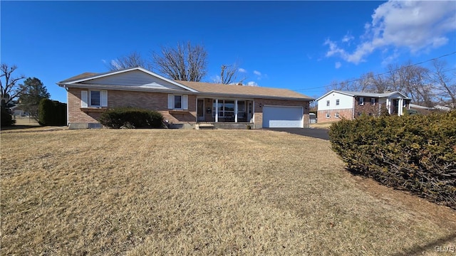 ranch-style home with a garage, driveway, a front yard, and brick siding