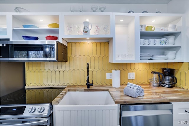 kitchen with open shelves, a sink, stainless steel appliances, white cabinets, and decorative backsplash