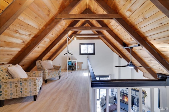 unfurnished room with a glass covered fireplace, wooden ceiling, vaulted ceiling with beams, and wood finished floors