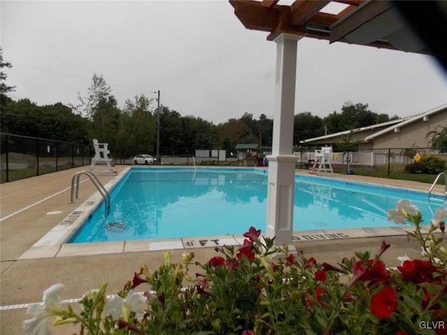 pool with a patio area and fence