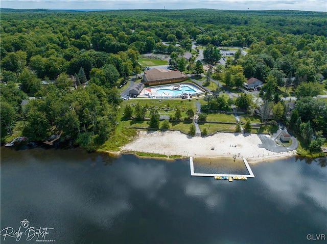 bird's eye view featuring a wooded view and a water view