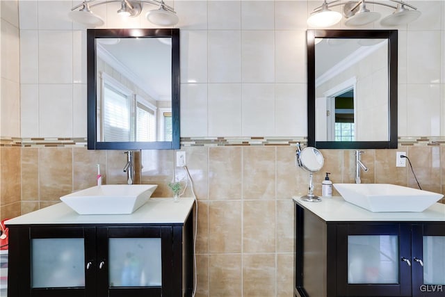 bathroom featuring ornamental molding, a sink, and tile walls