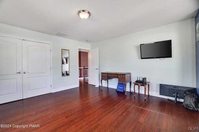 living room featuring wood finished floors, visible vents, and baseboards