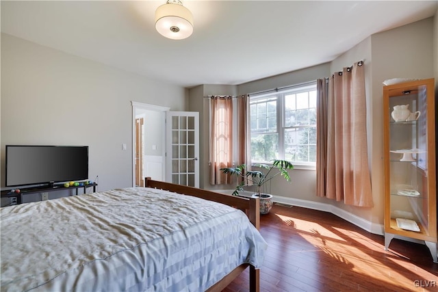 bedroom with hardwood / wood-style flooring and baseboards