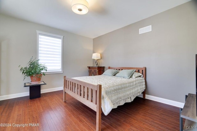 bedroom with visible vents, baseboards, and wood finished floors