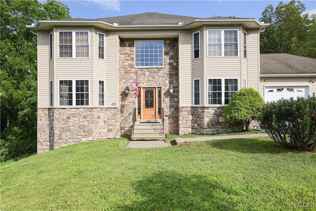 view of front facade with a garage, a front yard, and stone siding