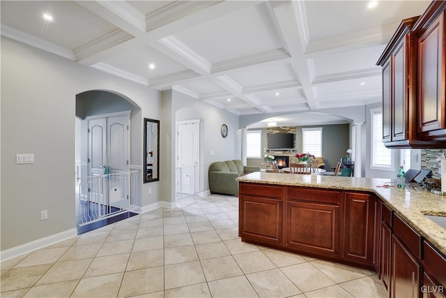 kitchen with a fireplace, coffered ceiling, and beam ceiling