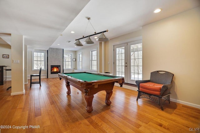 game room with french doors, light wood finished floors, recessed lighting, a large fireplace, and baseboards