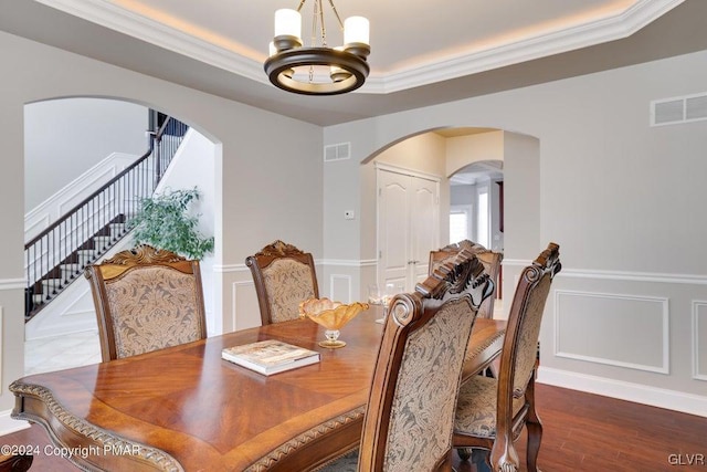 dining space with an inviting chandelier, visible vents, arched walkways, and a decorative wall