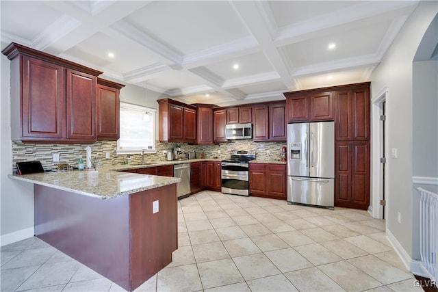 kitchen with a peninsula, a sink, appliances with stainless steel finishes, and dark brown cabinets