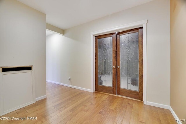 doorway to outside featuring light wood finished floors, french doors, and baseboards