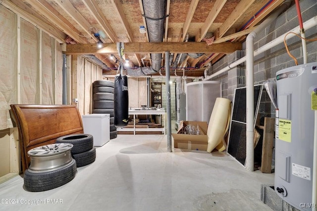 unfinished below grade area featuring electric water heater and fridge