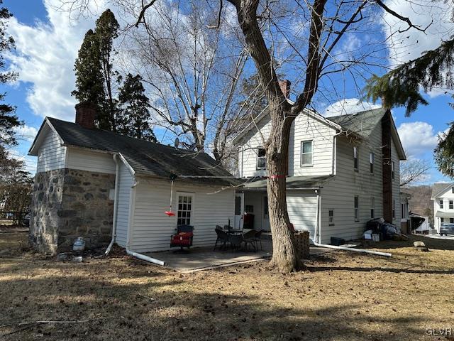 view of side of property with a chimney and a patio area