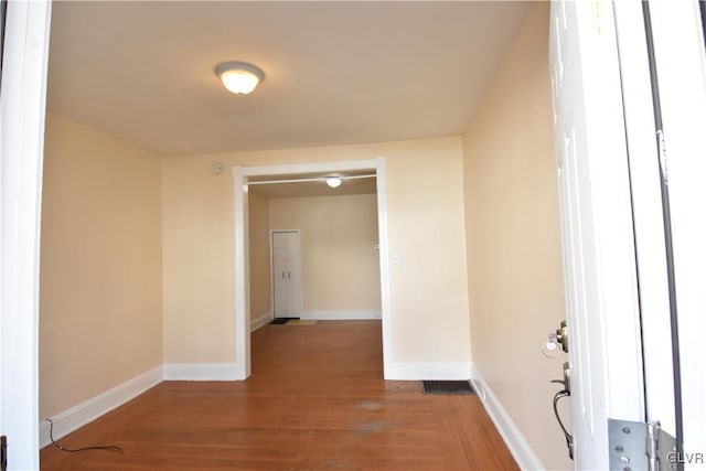 hallway featuring baseboards and wood finished floors