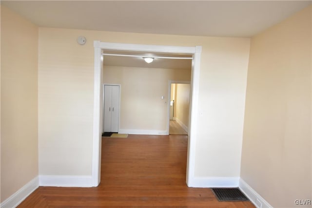 hall with wood finished floors and baseboards