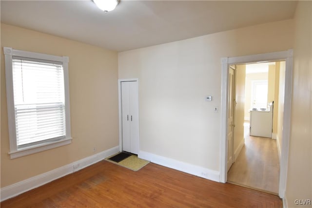 spare room featuring light wood finished floors and baseboards