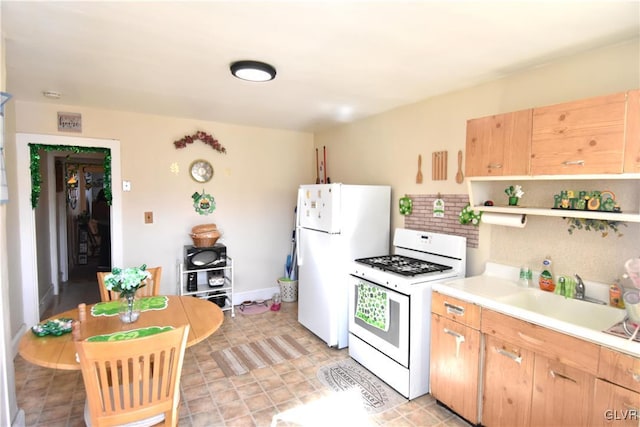 kitchen featuring light countertops, white appliances, a sink, and light brown cabinetry