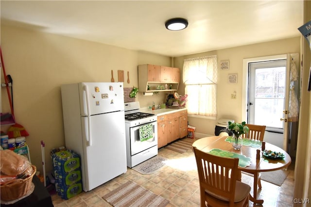 kitchen featuring light countertops, white appliances, a healthy amount of sunlight, and open shelves