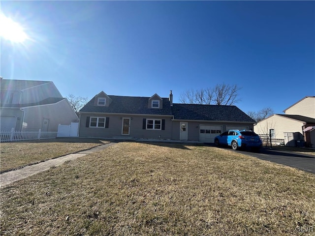 view of front of home with a garage, driveway, fence, and a front yard