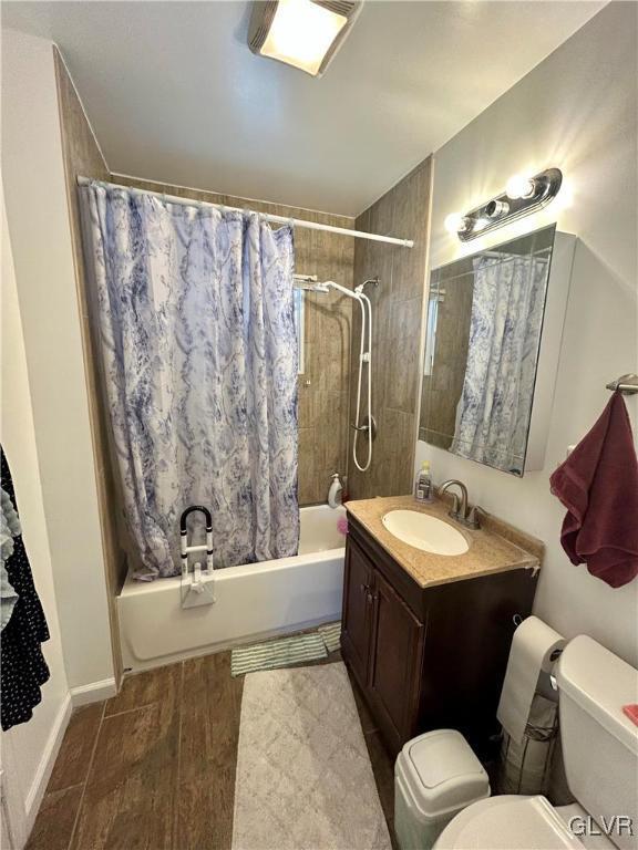 bathroom featuring shower / bath combo, vanity, toilet, and wood finished floors