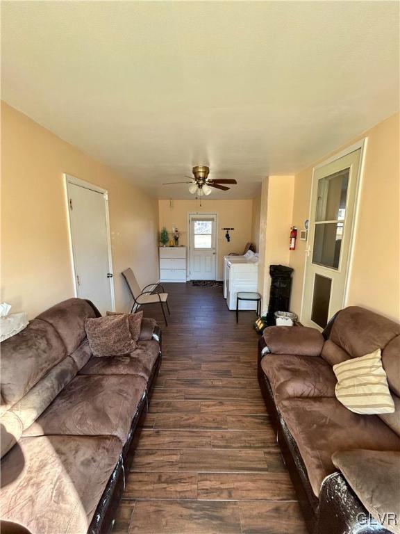 living area featuring ceiling fan, separate washer and dryer, and wood finished floors