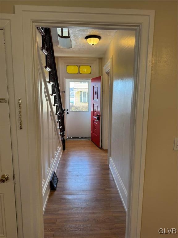 doorway with stairs and wood finished floors