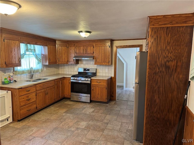 kitchen featuring a sink, stainless steel appliances, light countertops, backsplash, and exhaust hood