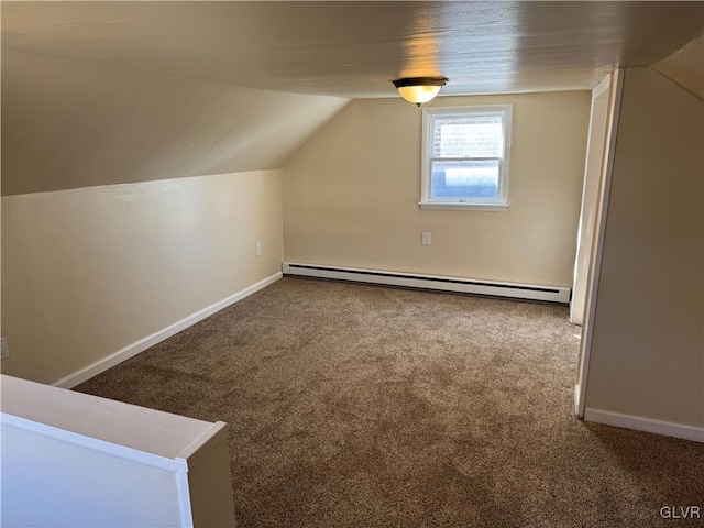 additional living space with a baseboard heating unit, vaulted ceiling, carpet flooring, and baseboards