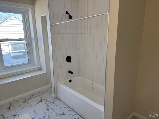 bathroom with marble finish floor, baseboards, and bathtub / shower combination