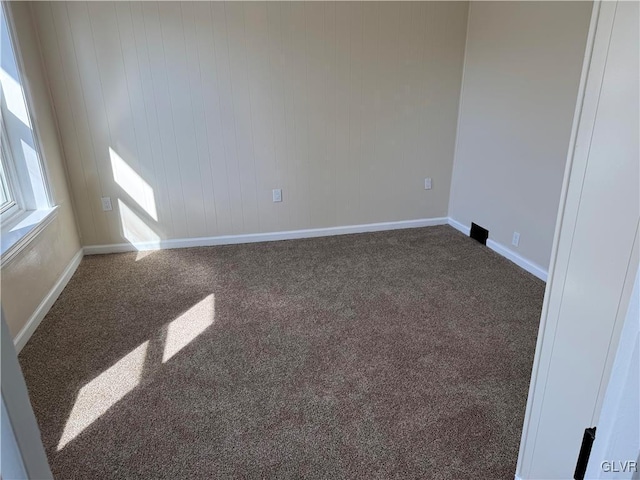 unfurnished room with carpet floors and baseboards