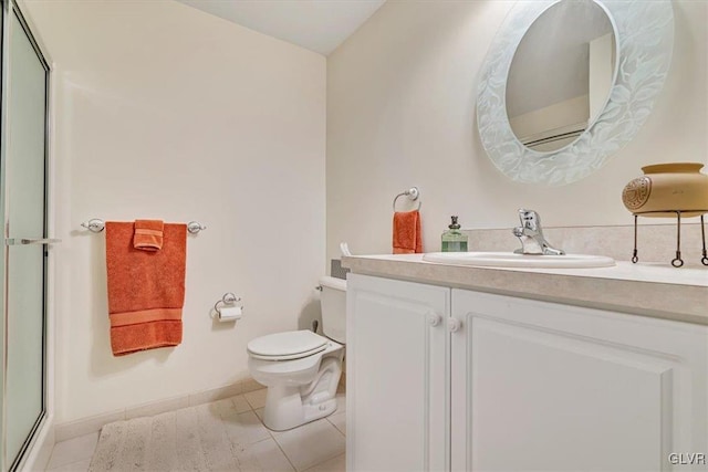 full bath with toilet, a shower with shower door, vanity, baseboards, and tile patterned floors