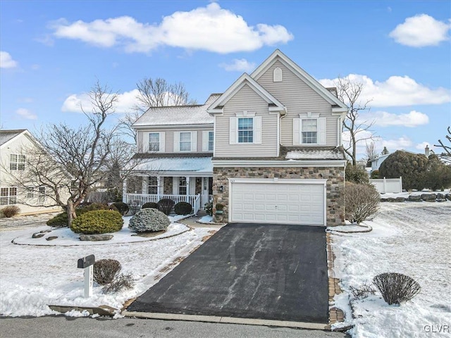 traditional home featuring a garage, driveway, a porch, and stone siding