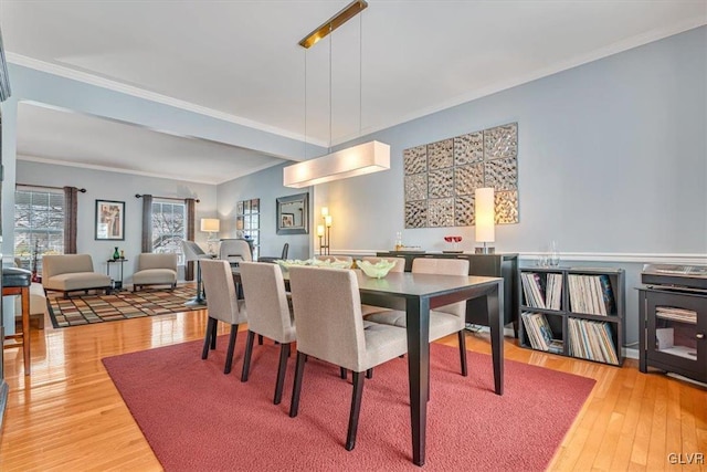 dining room with crown molding and light wood-style floors