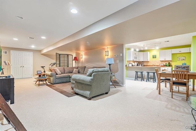 living area with recessed lighting, baseboards, light colored carpet, and track lighting