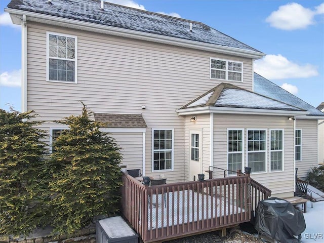 back of house featuring a shingled roof and a wooden deck