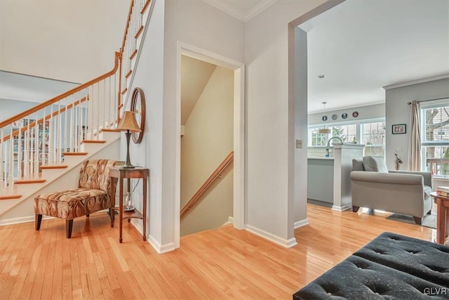 stairway with ornamental molding, hardwood / wood-style flooring, and baseboards