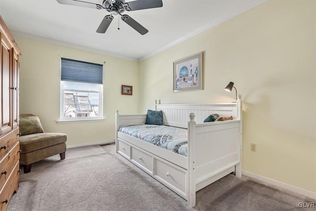 carpeted bedroom with ceiling fan, baseboards, and crown molding