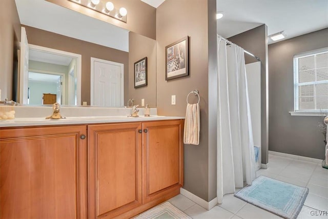 full bath with a shower with curtain, tile patterned flooring, baseboards, and vanity