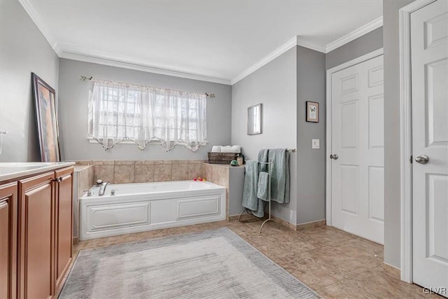 bathroom with a garden tub, baseboards, ornamental molding, and vanity