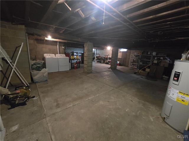 unfinished basement with electric water heater, independent washer and dryer, and concrete block wall