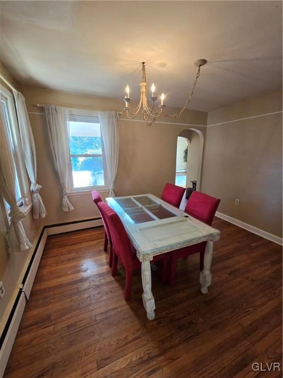 rec room with baseboards, dark wood finished floors, an inviting chandelier, arched walkways, and a baseboard heating unit