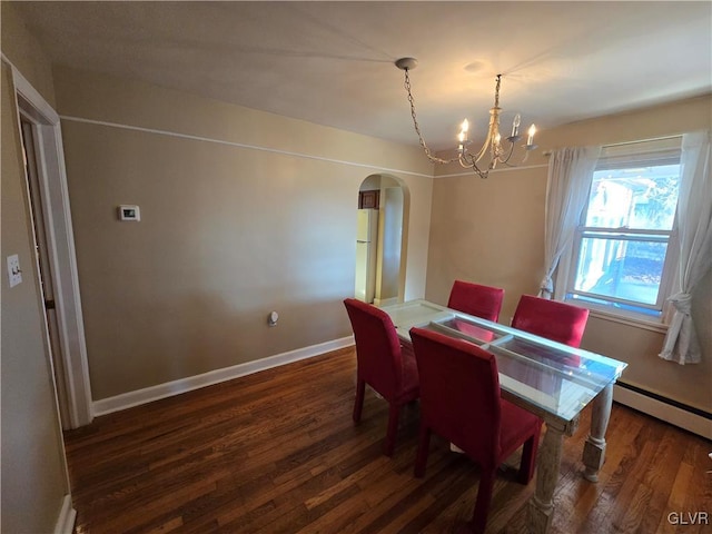 dining room with a baseboard radiator, wood finished floors, arched walkways, and baseboards