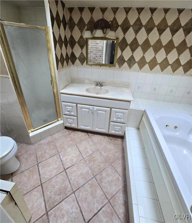 bathroom featuring tile patterned floors, tile walls, a shower stall, and vanity