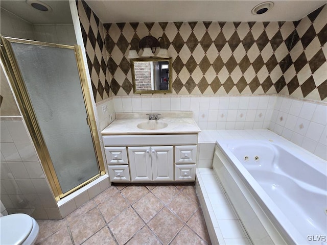 full bath featuring a stall shower, tile walls, vanity, and a whirlpool tub