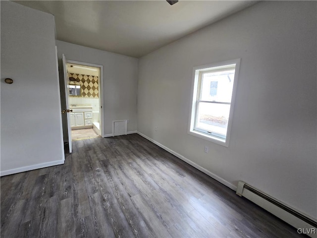 empty room featuring baseboards, baseboard heating, and dark wood finished floors