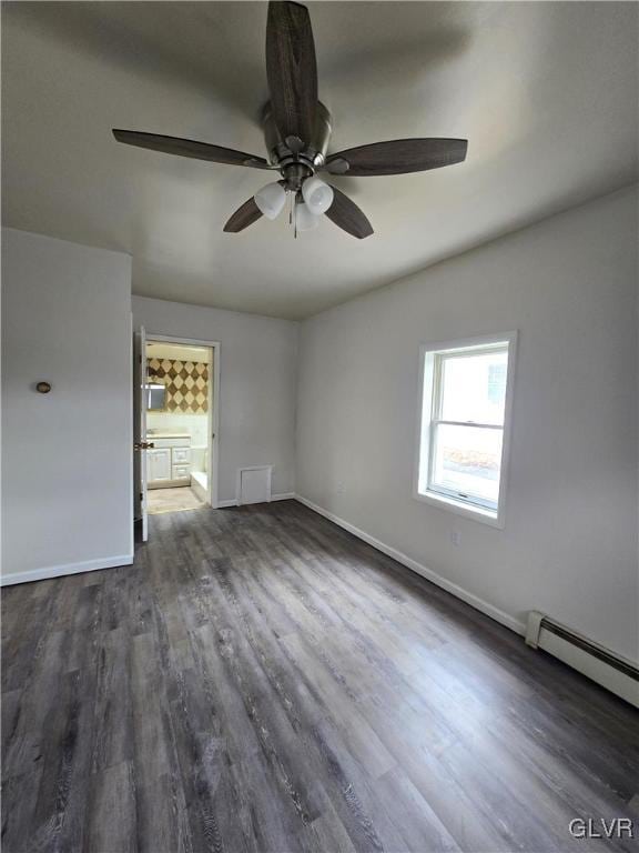 empty room with dark wood finished floors, baseboards, a baseboard heating unit, and ceiling fan