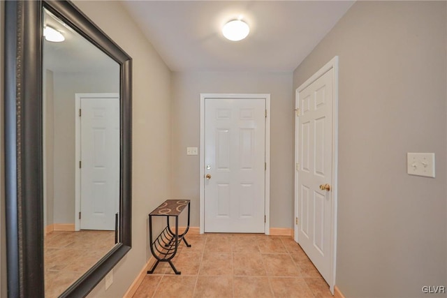 interior space featuring light tile patterned flooring and baseboards