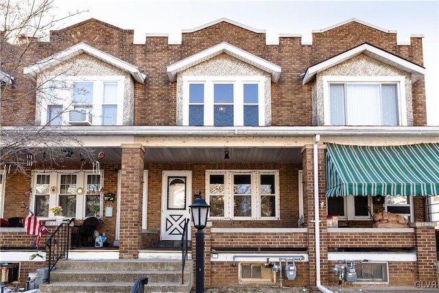 multi unit property featuring brick siding and covered porch