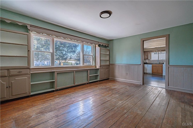 unfurnished room with a wainscoted wall, radiator, and hardwood / wood-style flooring