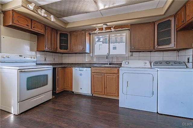 kitchen with tasteful backsplash, dark wood-type flooring, washing machine and dryer, white appliances, and a sink